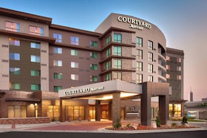 A Courtyard Marriott hotel with a modern design, featuring multiple floors and a prominent entrance with a covered area.