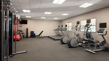 A gym with treadmills, elliptical machines, and weightlifting equipment.