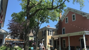 A building with a red facade, a green tree in front, and a sign reading "OPENSPACE". - American Beech Hotel (Greenport)