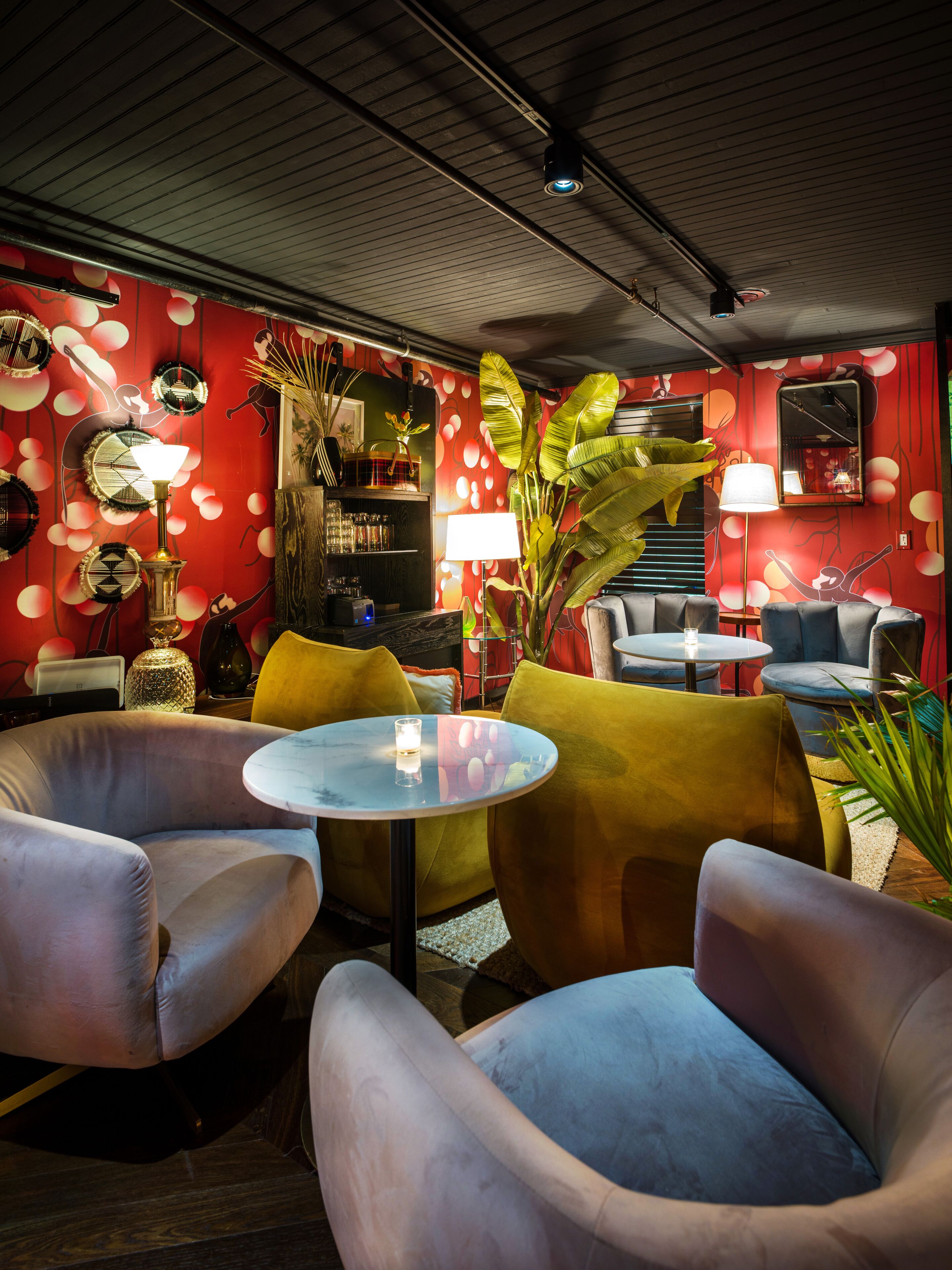 Un rincón tranquilo con asientos cómodos, una pequeña mesa y un muro decorativo con diseños circulares.