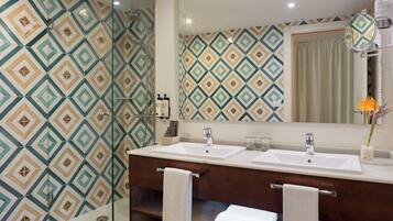 A bathroom with a shower, two sinks, and a mirror.