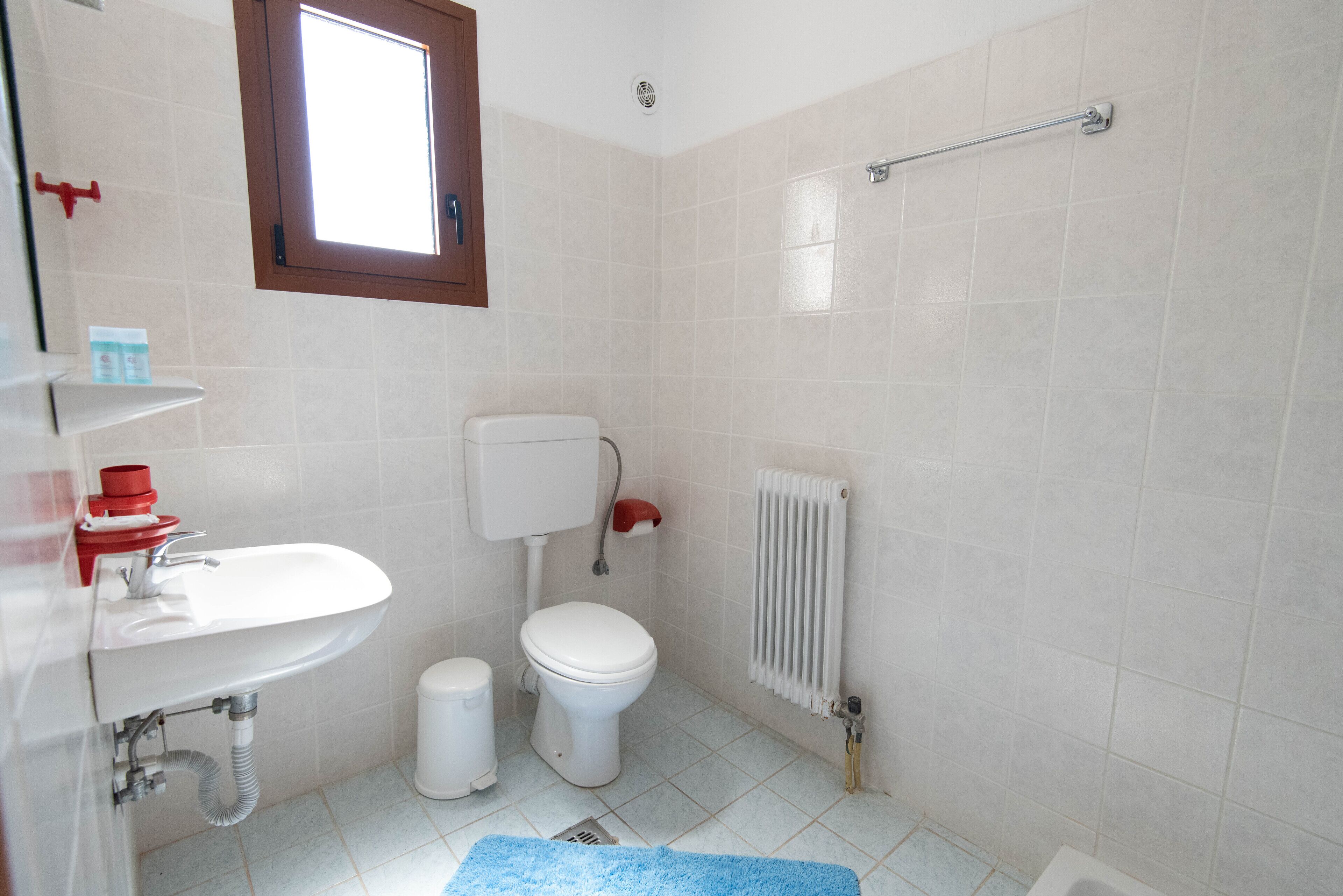 A bathroom with a white sink, toilet, and shower area.