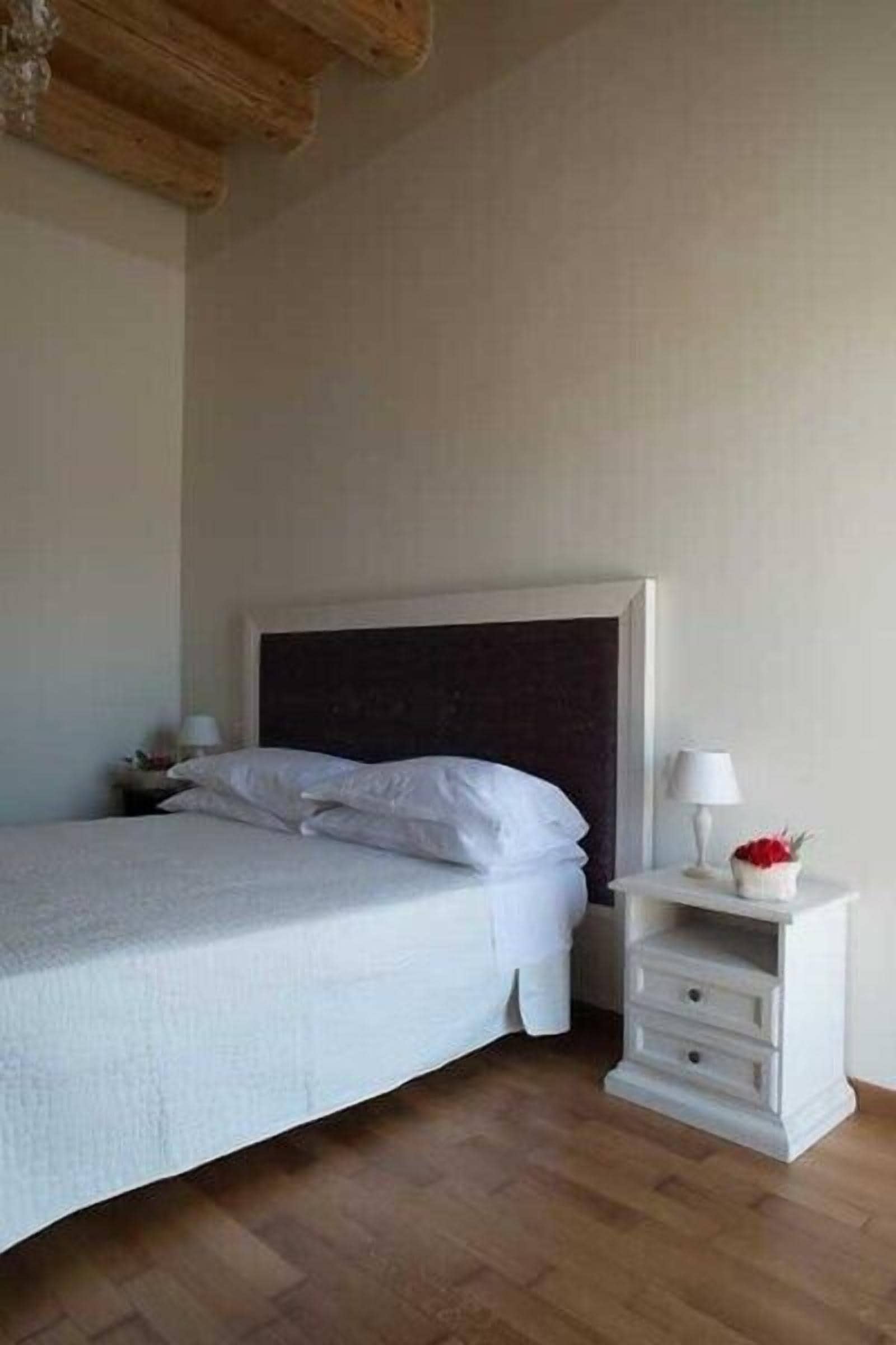 Un dormitorio con cama, mesita de noche y cómoda.