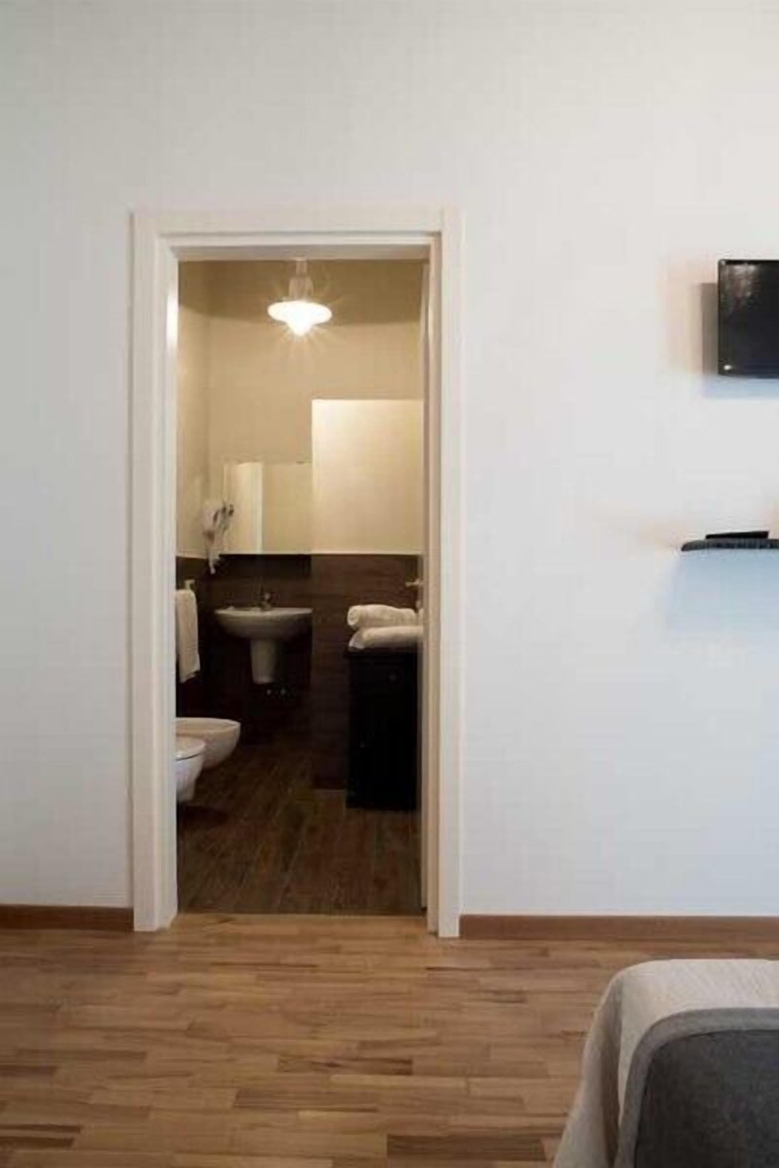 A modern bathroom with a sink, toilet, and mirror.