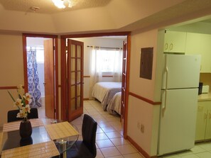 A compact living space with a dining area, a bed, and a kitchen. - SoBe Apartments (Miami Beach)