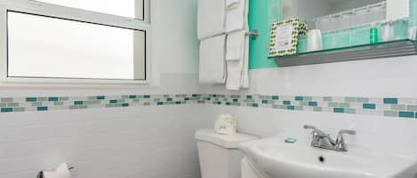 Un baño con inodoro, lavamanos y ventana.