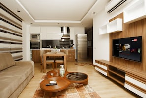 Departamento, 1 habitación | Área de sala de estar | Televisión LED de 40 pulgadas con canales vía satélite y televisión