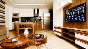 Eine moderne Küche mit integriertem Fernseher, Holzschränken und einem Essbereich mit einem einzigartigen Couchtisch in Gitarrenform.