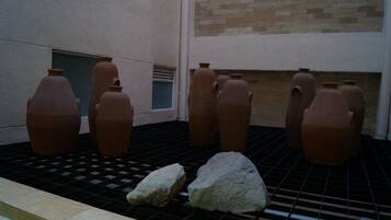 Terracotta pots arranged on a tiled floor in a courtyard.