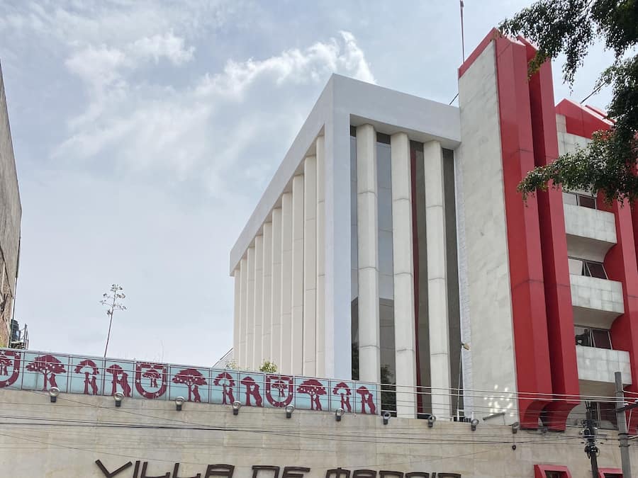 The exterior of Villa de Madrid hotel with a modern facade, a prominent entrance, and a visible sign for the hotel.