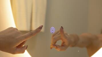 A close-up of two hands interacting with a touch-sensitive surface, displaying a power symbol.