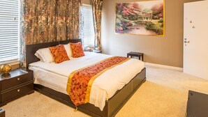 A bedroom with a large bed, a nightstand, a bedside table, a wall-mounted painting, and a door. - Sunny and Elegant Villa (Newark)