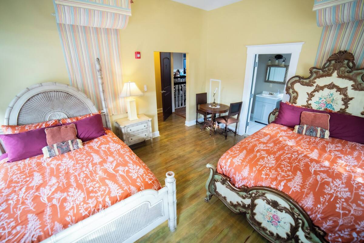 Ein Hotelzimmer mit zwei Betten, einer Sitzecke und einem Badezimmer.