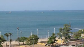 A coastal view with a beach, palm trees, and a few boats on the water. - Hotel Fortaleza Inn (Fortaleza)