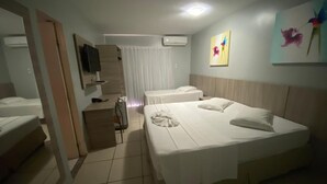 A hotel room with two single beds, a desk with a chair, a television, and a window with curtains. - Hotel Fortaleza Inn (Fortaleza)