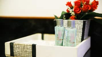 A tray with two bottles and a bouquet of red roses.