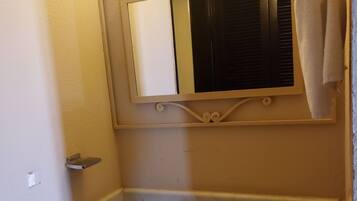 A bathroom with a sink, mirror, and towel rack.