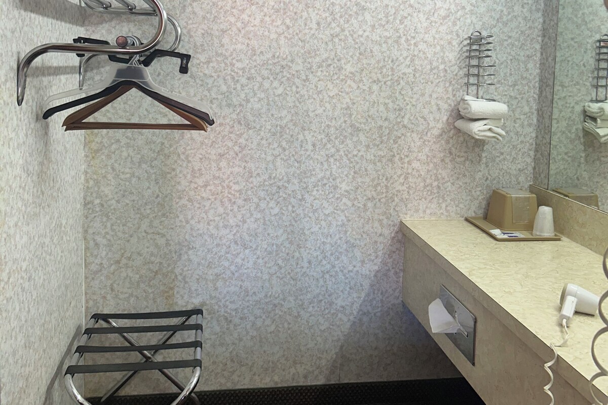 A compact bathroom with a towel rack, a mirror, and a small sink area.