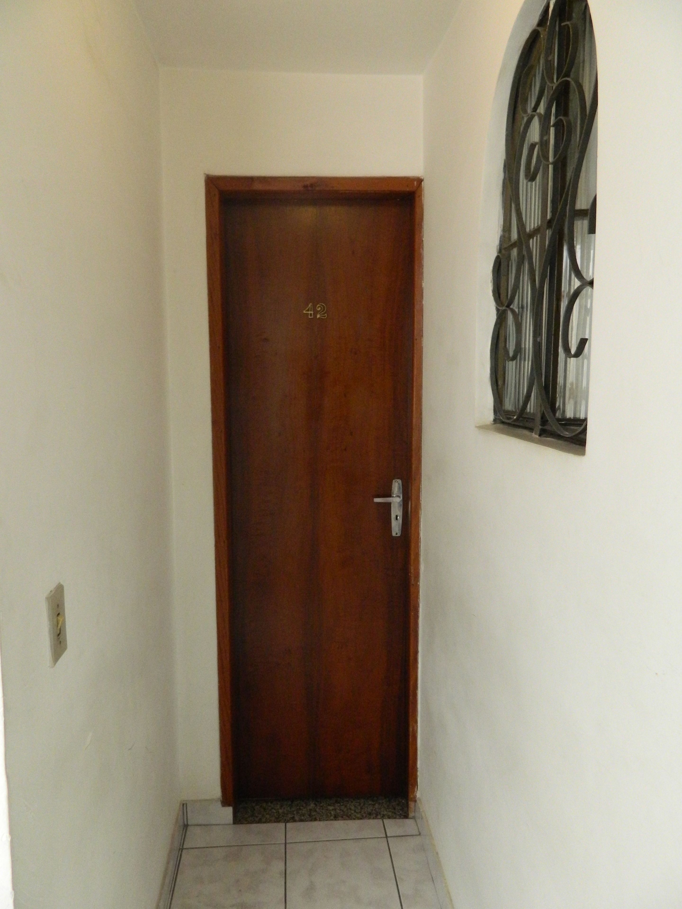 A wooden door with the number 42, a metal handle, and a window with decorative iron bars.