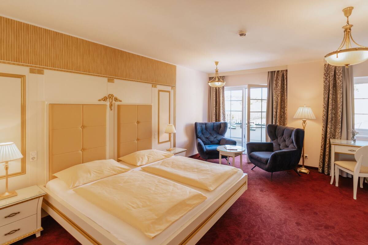 Una habitación de hotel con una cama grande, un escritorio, una silla y una mesita.