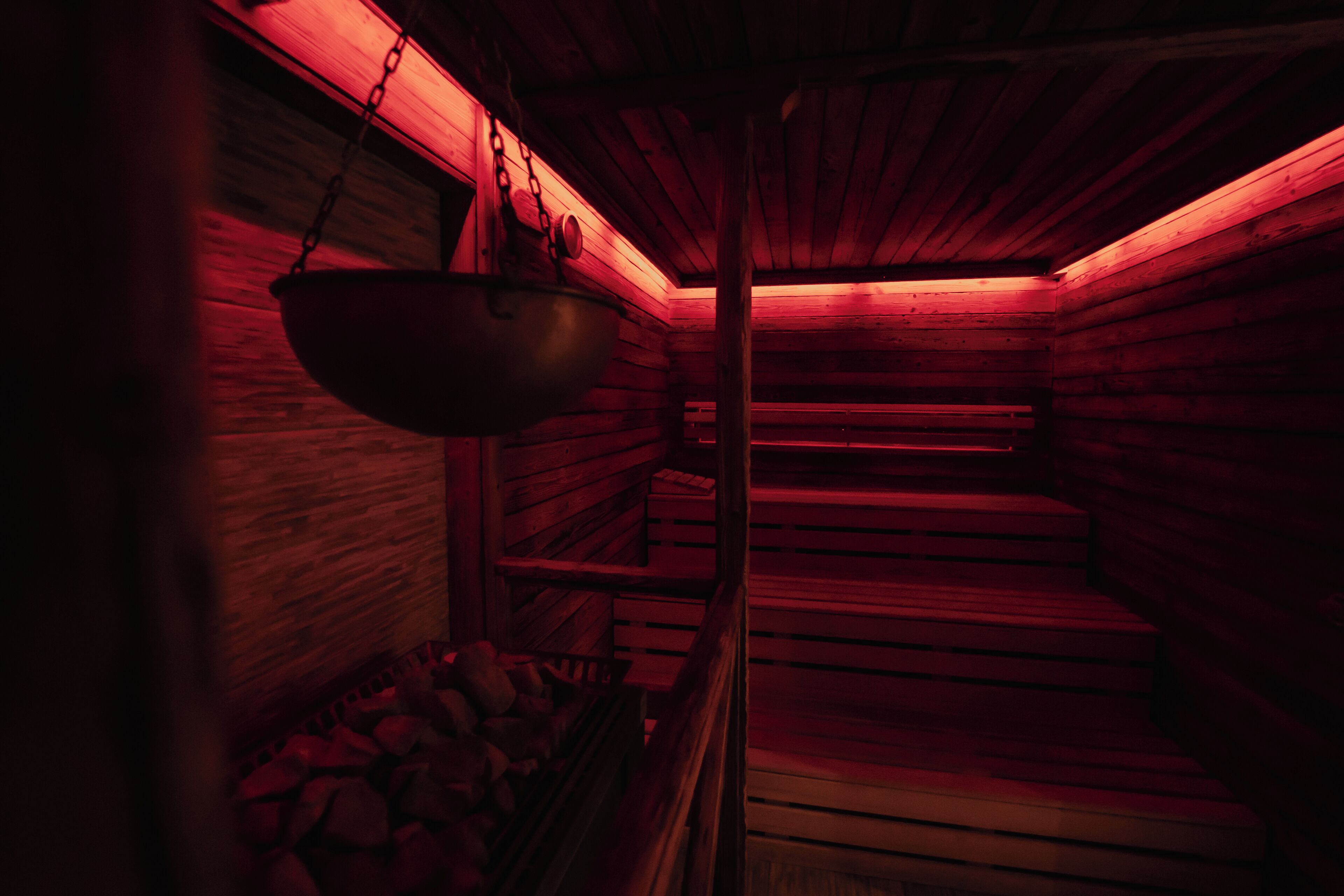 Eine Sauna mit Holzwänden und einem hängenden Waschbecken.