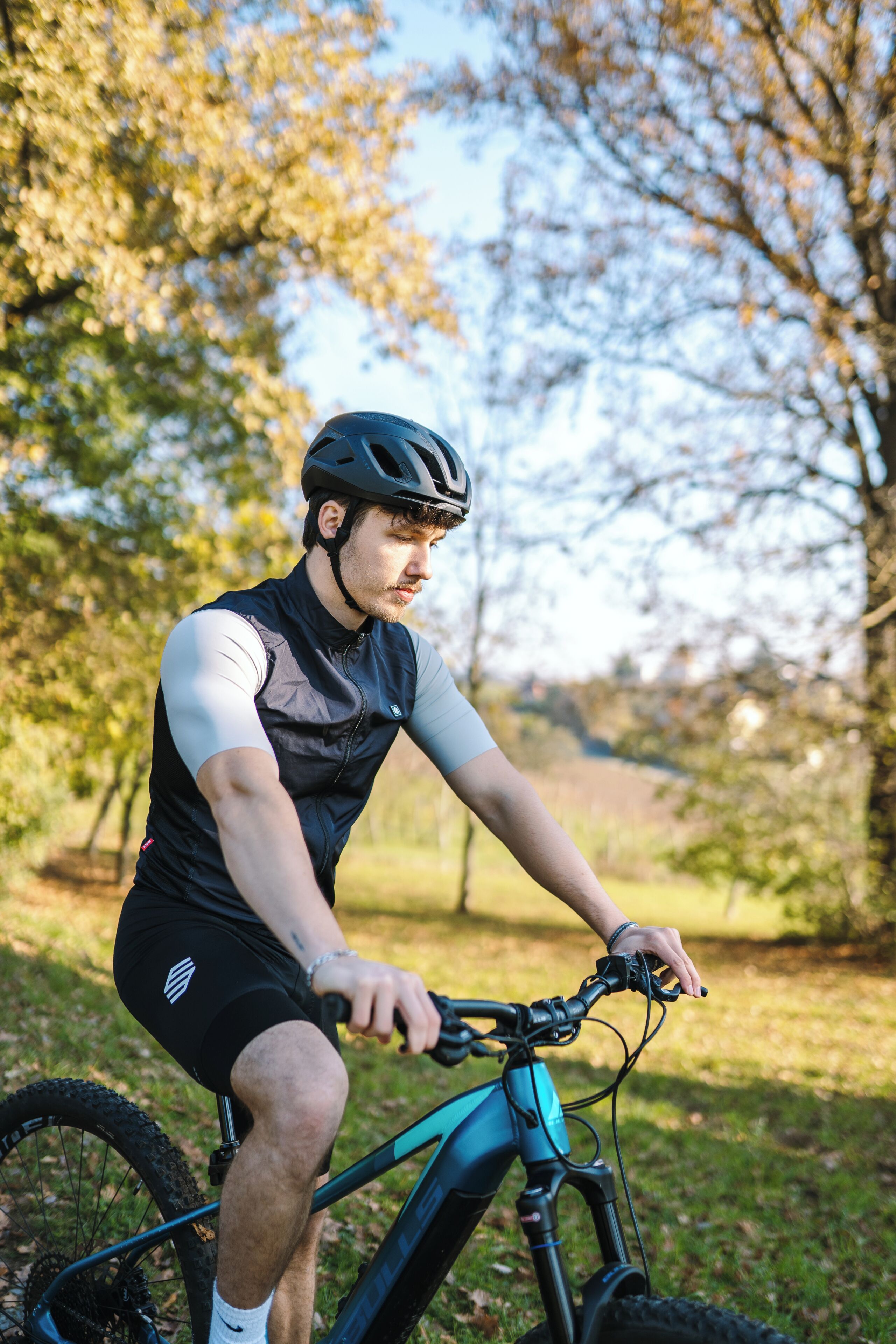 A person riding a mountain bike in a natural setting with trees and grass.