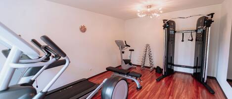 A gym with treadmills, elliptical machines, and weightlifting equipment.