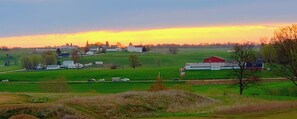 A rural landscape with a barn, open fields, and a few scattered buildings. - Berlin Heritage Inn (Millersburg)