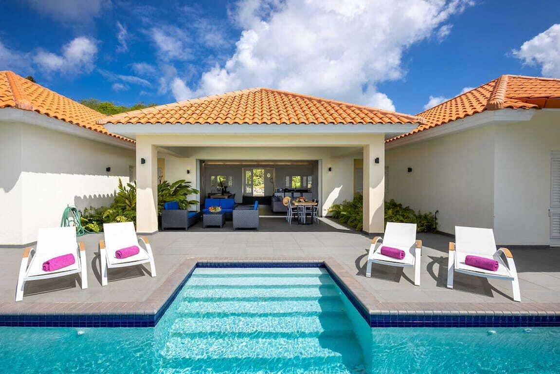 Una piscina con lettini e una zona patio coperta.