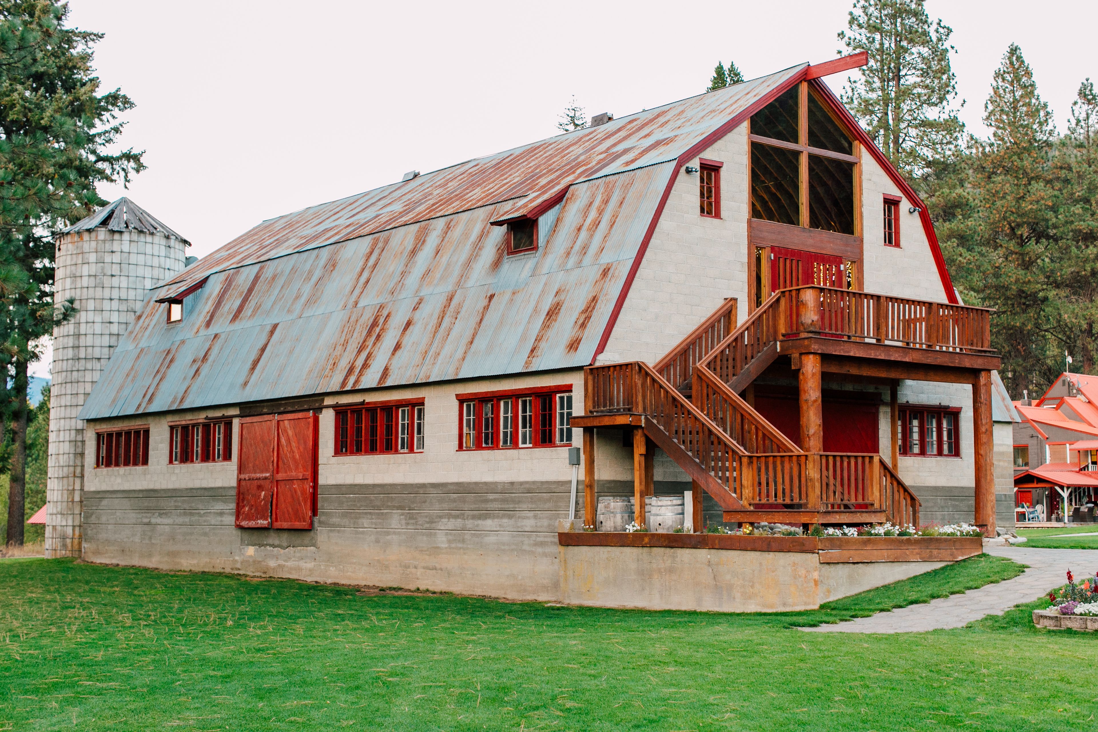 A rustic barn-style building with a large porch and wooden staircase.