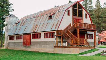 A rustic barn-style building with a large porch and wooden staircase.