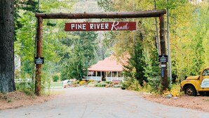 En rustik træport med et skilt, der står "Pine River Ranch".