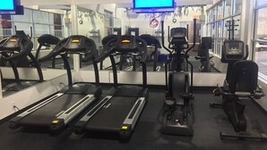 A gym with treadmills, elliptical machines, and a mirrored wall. - Americas Best Value Inn & Suites Boise (Boise)