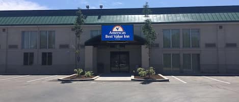 A Best Value Inn with a green roof, a signboard, and a parking lot.