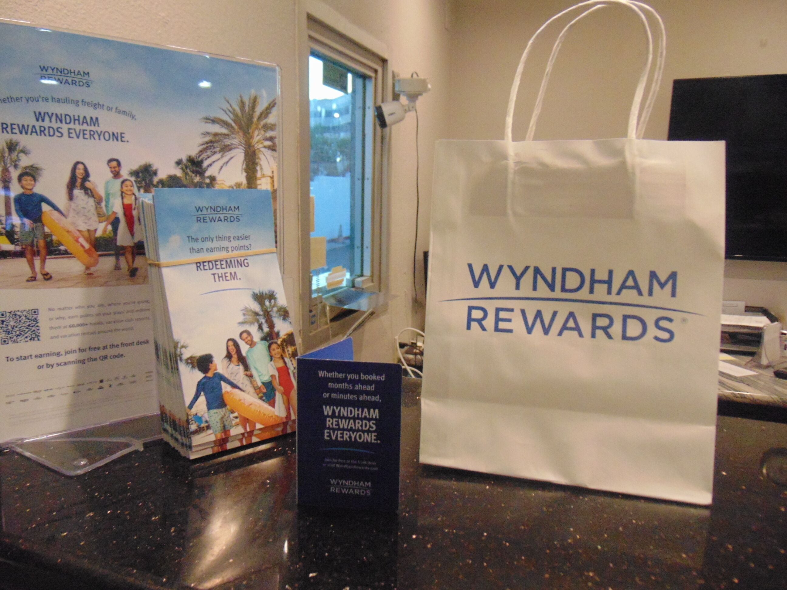 A Wyndham Rewards promotional display with a brochure and a tote bag.