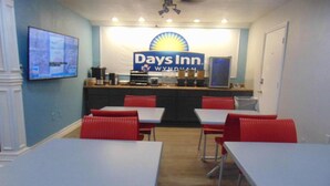 A Days Inn by Wyndham with a reception area, tables, and red chairs. - Days Inn by Wyndham Victorville/Hesperia I-15 & Palmdale Rd (Victorville)