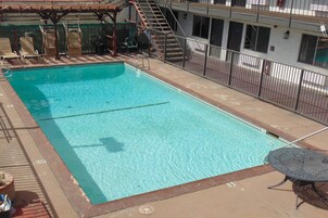 Una piscina al aire libre de temporada, sillones reclinables de piscina