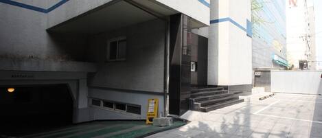 Un edificio moderno con un diseño arquitectónico distintivo, que presenta un alero pronunciado y una escalera que conduce a la entrada.