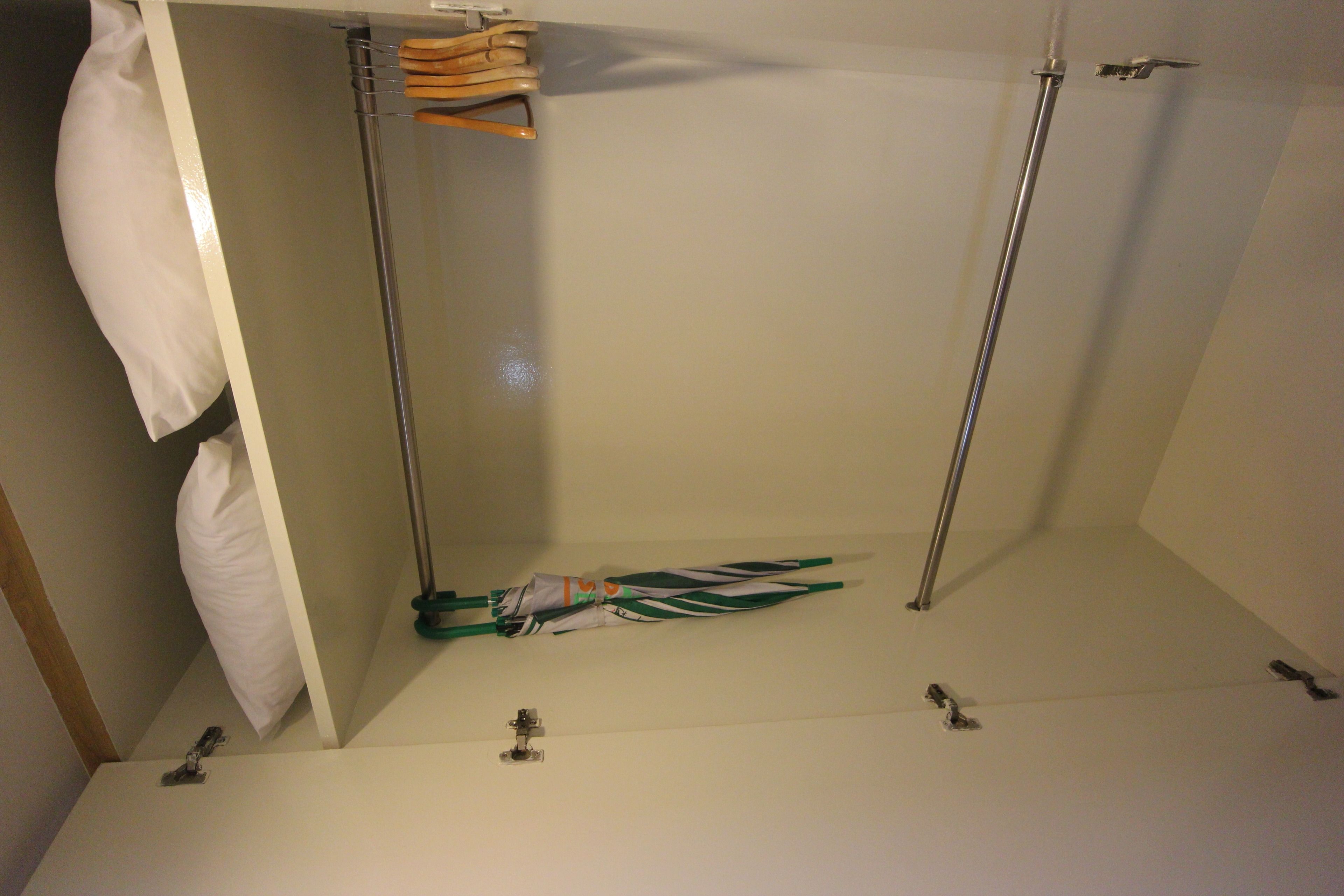 A room with a white wall, a wooden door, and a metal rod structure.