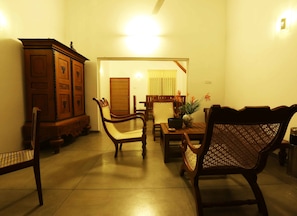 A traditional dining room with wooden furniture, a cabinet, and a door leading to another room.