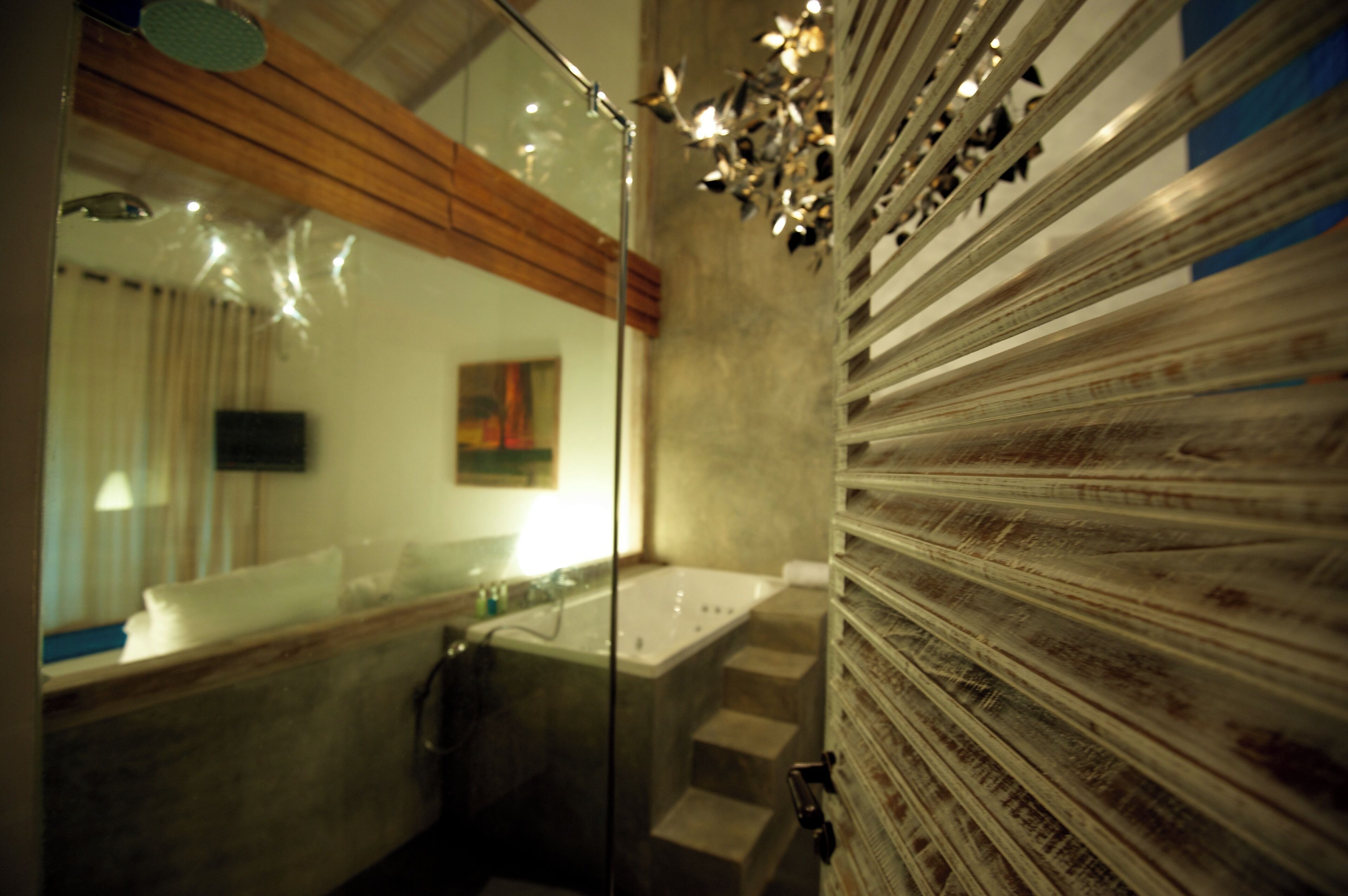 A bathroom with a glass shower enclosure, a bathtub, and a large mirror.