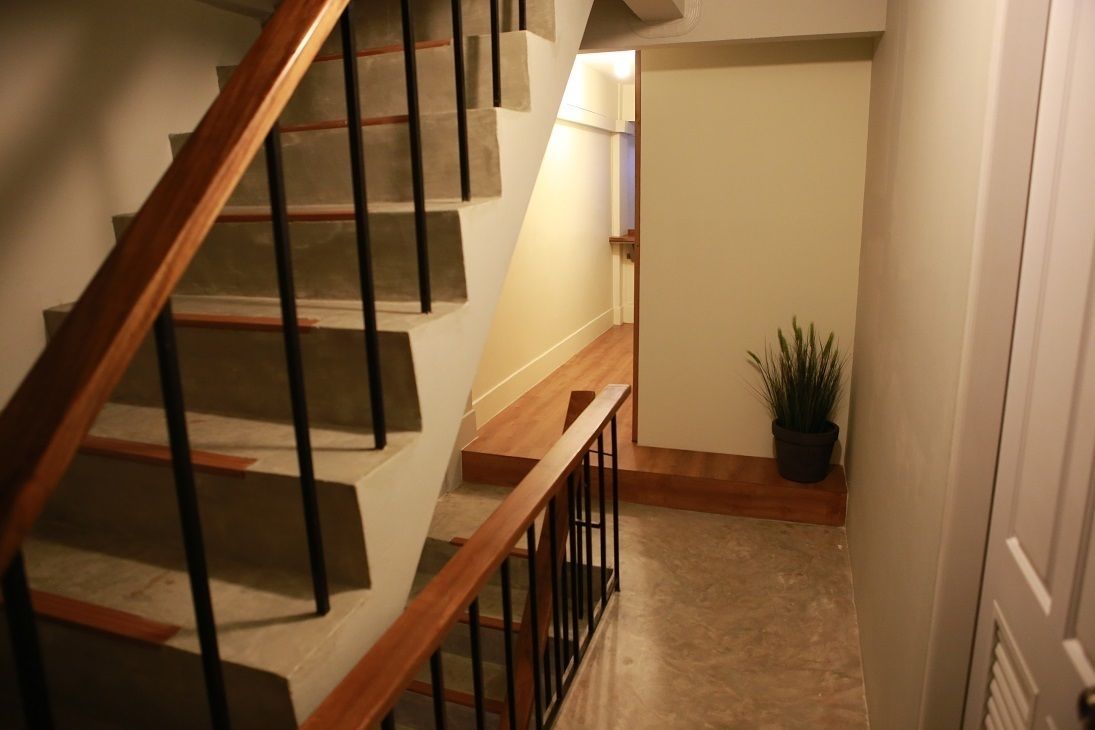A staircase with wooden handrails and a potted plant on the landing.