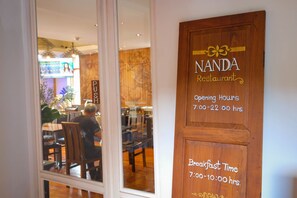 Letrero de restaurante con horario de atención y horario de desayuno.