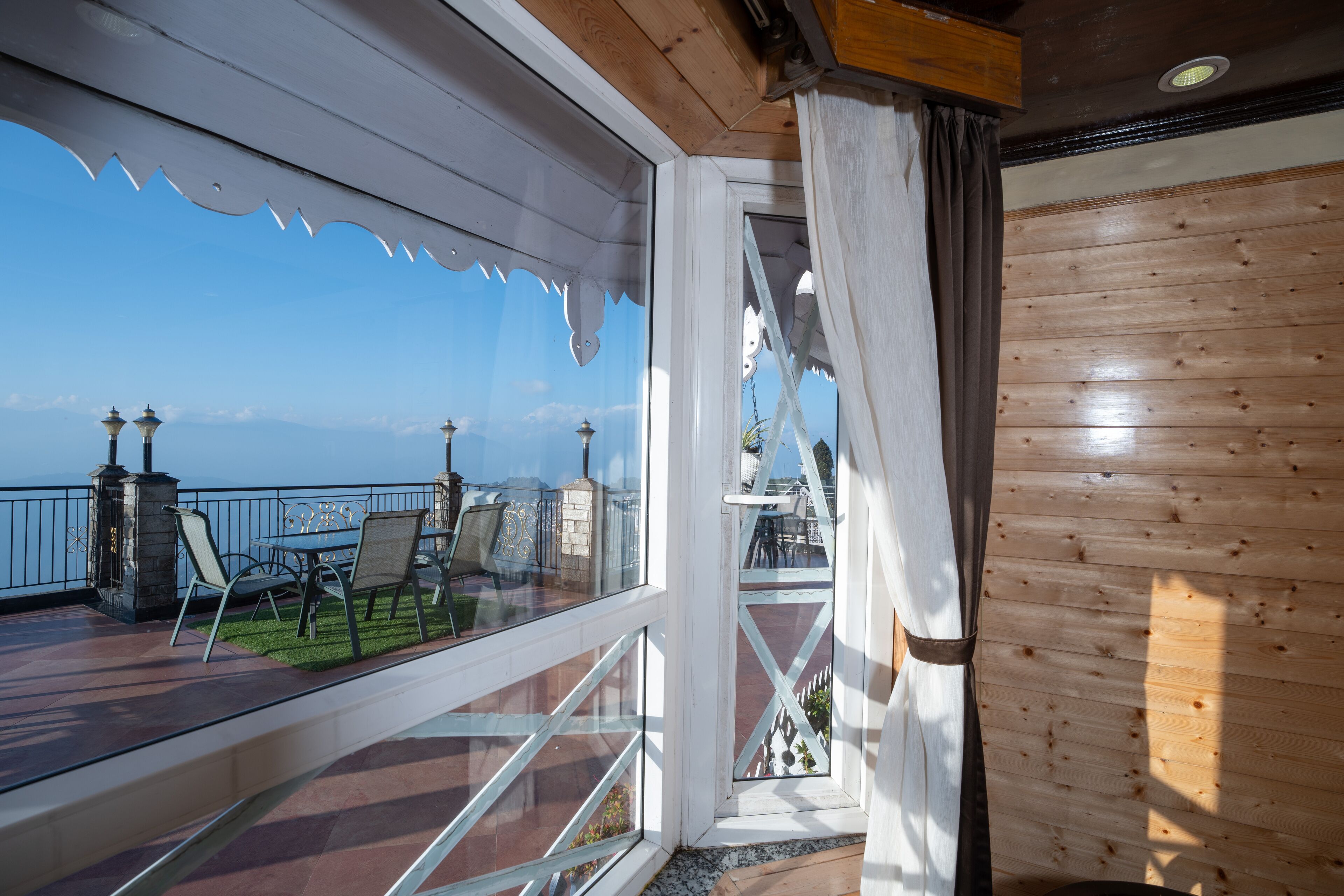A wooden interior with a balcony overlooking a scenic view.