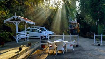 A parking area with white cars, a gazebo, and outdoor seating.