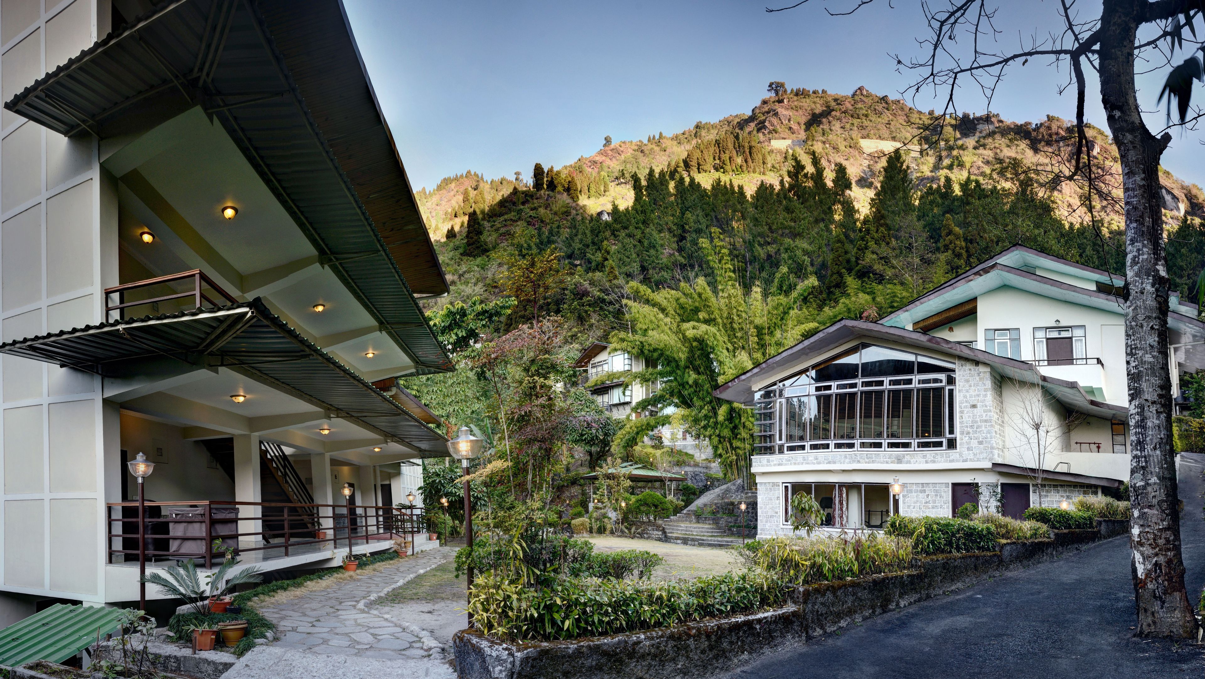 A modern building with a balcony and a view of a mountainous landscape.