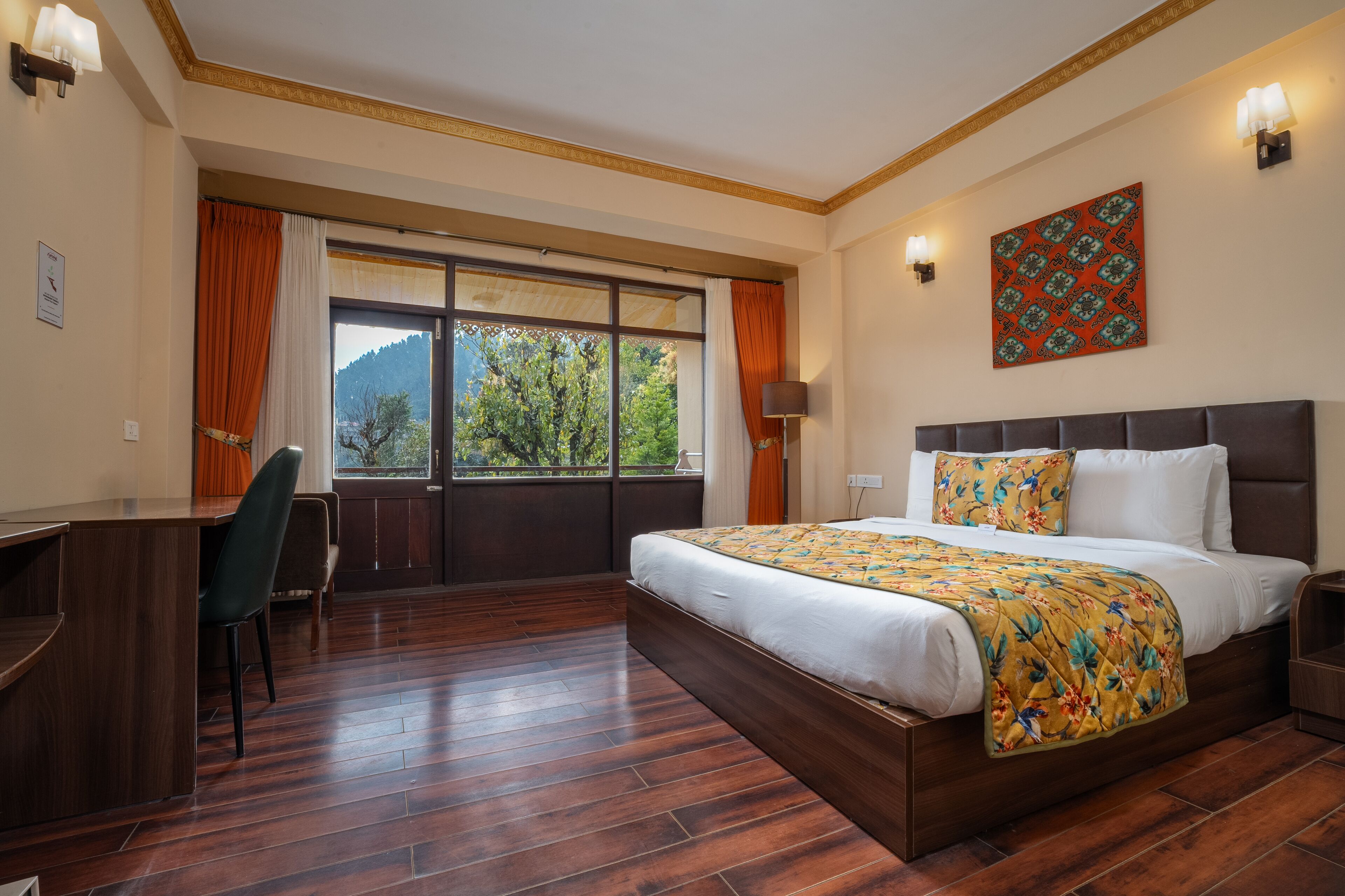 A hotel room with a large bed, a desk, and a view of the outdoors.