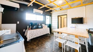 A kitchen with a sink, microwave, and coffee maker, a table with chairs, and a TV on the wall. - Hotel Pagoda (Nara)
