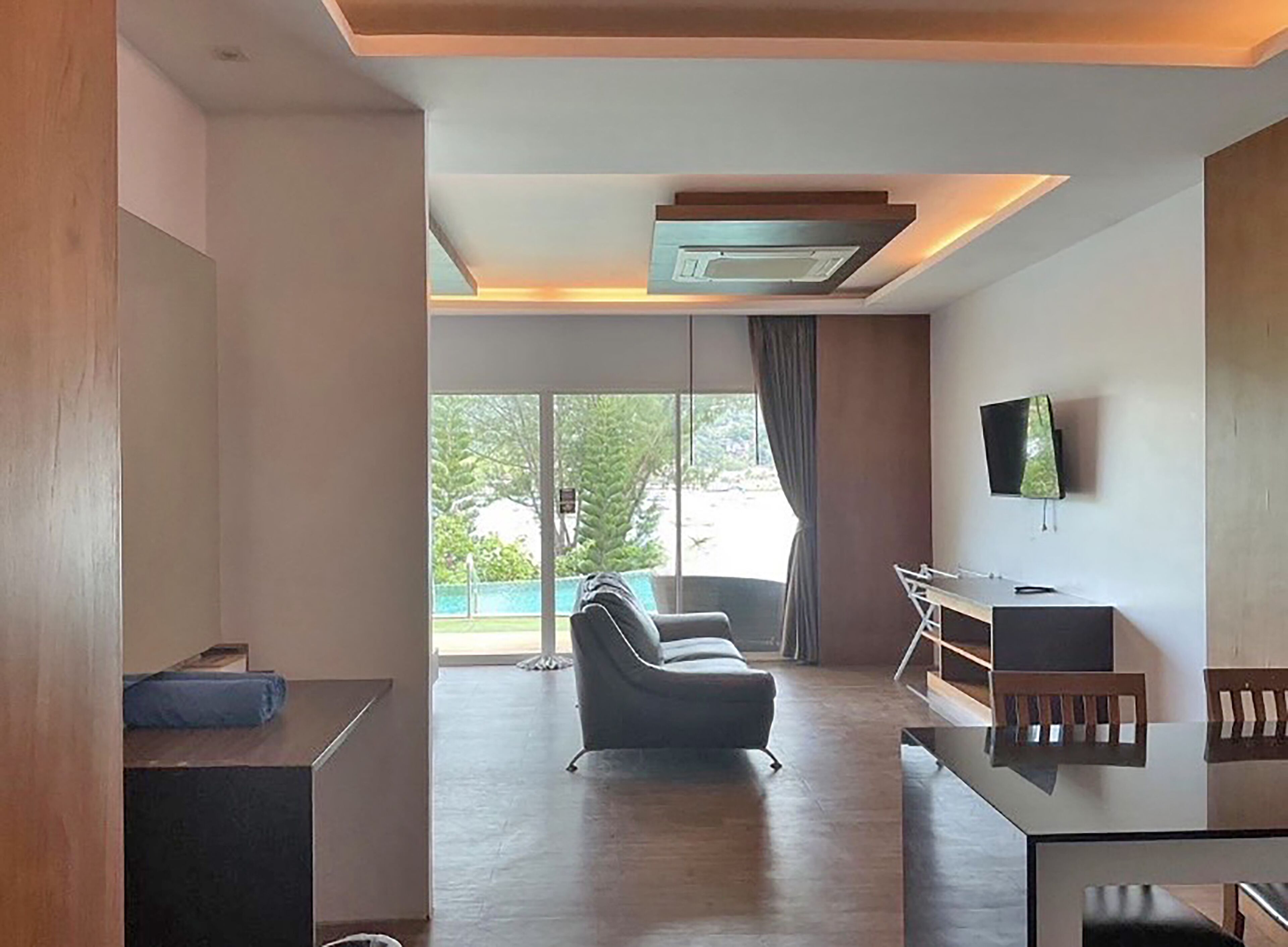 Una sala de estar moderna con un sofá, un televisor y un escritorio.