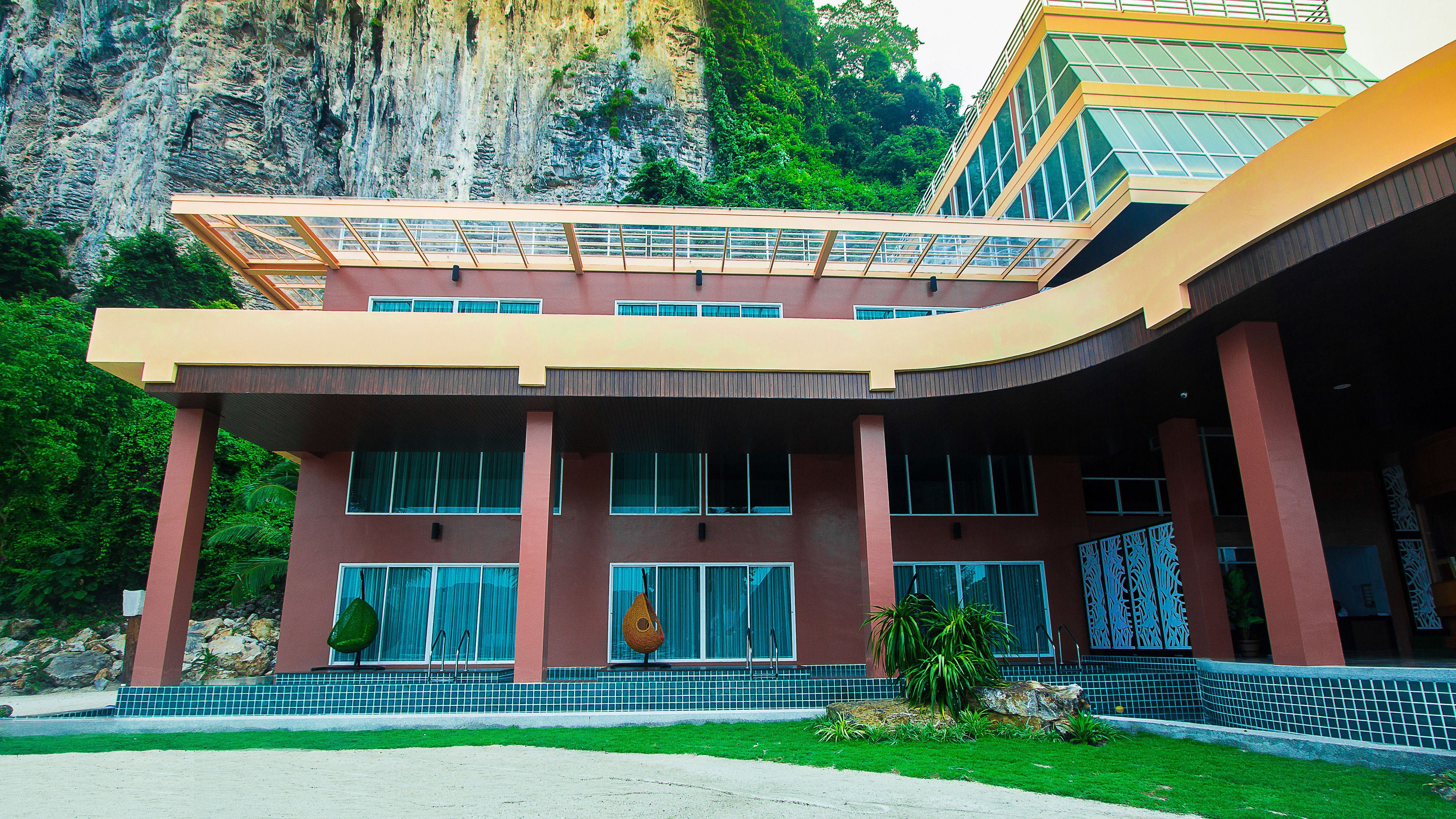 A modern building with a curved facade, large windows, and a prominent entrance with steps.